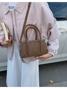 Brown matte faux leather bowling bag with dual handles and adjustable shoulder strap detail