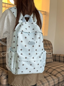 Light blue floral minimalist backpack for students in a cozy indoor setting