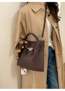 Deep brown lychee leather handbag with silver clasp and a cute knitted bear charm accessory