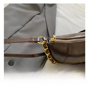 Detail of gold metal hook and zipper on dark brown oil-wax leather shoulder bag