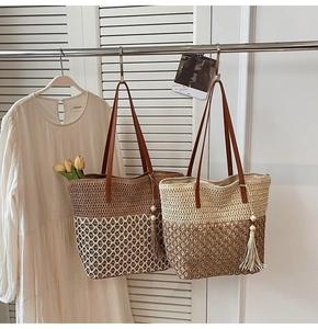 Detail of woven straw tote bags with leather handles and decorative fringe tassel