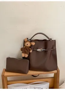 Detailed close-up of dark brown lychee grain leather tote bag with silver metal twist lock