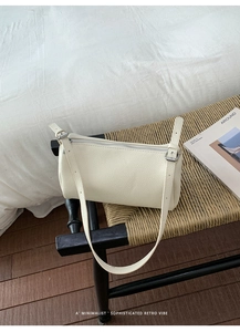 Close-up of cream crossbody bag with lychee texture and silver zipper detail
