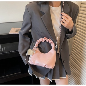 Sac à main rose avec poignée froncée et breloque cœur en perles en vue de style de vie