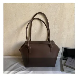 Vue détaillée de la texture du cuir grainé marron de qualité sur le grand sac cabas