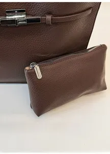 Detailed macro of brown lychee grain leather handbag set with silver metal hardware locks