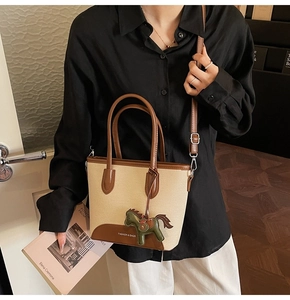 Detalle de bolso bucket en lona beige y cuero marrón con colgante de caballo en modelo