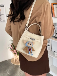 Chic white lychee grain bucket bag with silver lock and a cute crochet bear charm