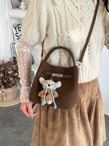 Dark brown pebbled leather bucket bag with silver lock and cute bear charm accessory