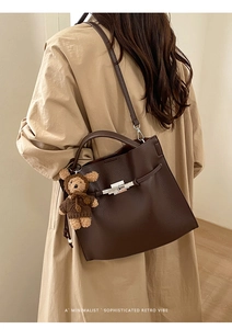Brown litchi grain leather handbag with silver clasp and teddy bear charm detail