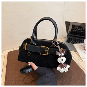 Detail of black suede shell bag with gold buckle and schnauzer leather charm