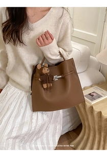 Brown litchi grain leather bucket bag with silver lock and cute bear charm pendant
