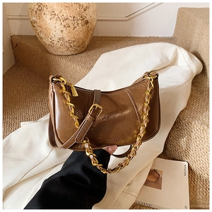 Detailansicht der dunkelbraunen Vintage-Tasche mit glänzender Öl-Wachs-Textur und Goldkette