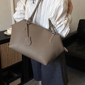 Detailed macro of brown lychee grain leather tote bag with fine stitching and hardware