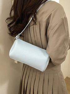 Minimalist light blue barrel crossbody bag with lychee texture leather on model