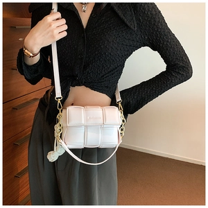 Gros plan du sac à bandoulière blanc tissé avec chaîne dorée et nœud décoratif