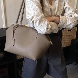 Minimalist grey-brown leather tote bag side view showing large capacity and slim strap