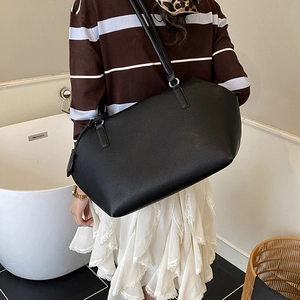 Close-up of black tote bag with lychee grain texture and metal hardware detail