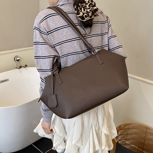 Detailed texture of high-quality dark brown lychee grain leather tote bag with fine stitching