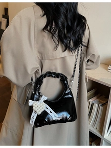 Sac à main en cuir verni noir avec poignée plissée, nœud en dentelle et breloque en perle