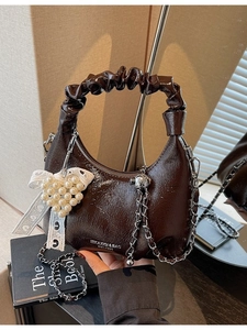 Sac à main croissant marron foncé avec anse plissée, chaîne argentée et pendentif perle