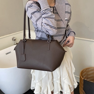 Detailed macro view of deep brown lychee grain leather shoulder bag with sleek straps