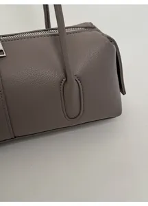 Close-up of pebble grain leather texture and silver zipper on this minimalist bowling bag