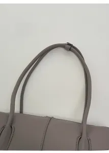 Detailed close-up of light purple litchi grain leather handle with silver metal hardware