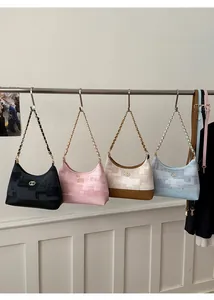 Détail de la texture jacquard et du logo métallique sur les sacs à bandoulière chaîne