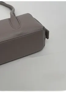 Detail of the wide base and lychee grain texture on this dark gray leather shoulder bag