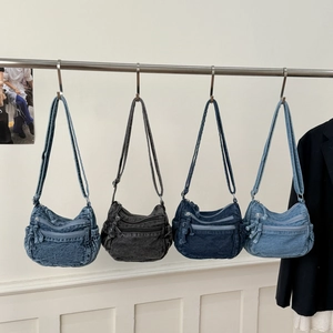 Detail of four denim tote bags in varied washes with multi-pocket design and adjustable straps