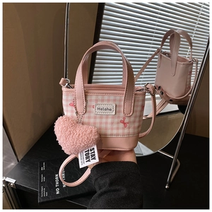 Detail of pink plaid bucket bag with heart pendant and adjustable leather shoulder strap
