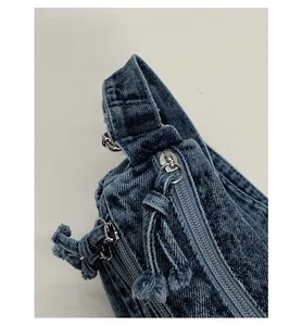Close-up detail of smooth zipper with denim puller on a blue vintage washed tote bag