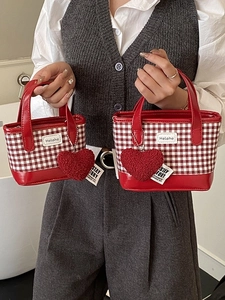Red plaid bucket bag with heart charm shown in a large and small size lifestyle display