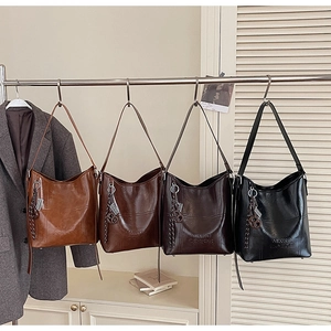 Detail view of large bucket bags in brown and burgundy with MIXXO embossed logo