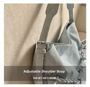 Detail of adjustable strap and blue hobo bag with braided chain decoration