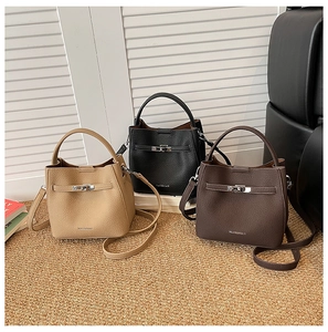Detail of retro leather bucket bags with metal twist locks in khaki, black, and brown