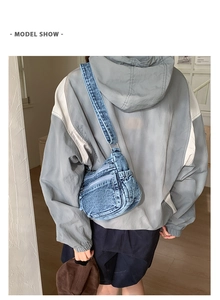 Detail of blue denim crossbody bag with multiple zipper pockets and adjustable strap