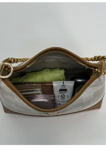 Vue détaillée du compartiment intérieur spacieux du sac à bandoulière beige monogrammé