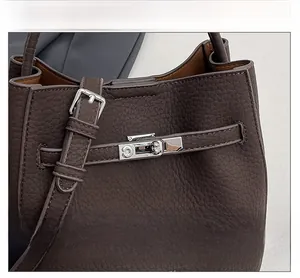 Detail of silver twist lock and litchi texture on dark brown leather handbag