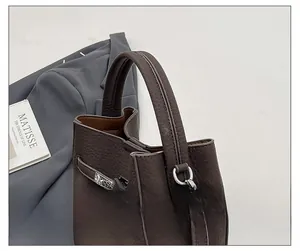 Detailed macro of dark brown lychee grain leather handbag with silver hardware clasp