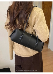 Black retro minimalist pillow shoulder bag shown in a lifestyle street style outfit