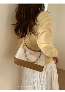 Détail du sac vintage avec bandoulière chaîne dorée et tissu jacquard géométrique