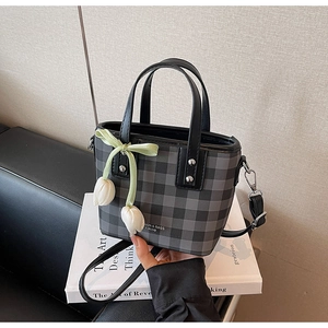 Vue détaillée du sac seau avec texture à carreaux gris et pendentif tulipe