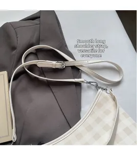 Détail de la bandoulière réglable avec boucle argentée sur le sac cabas à damier crème