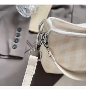 Gros plan détaillé de la quincaillerie en métal argenté d'un sac seau à motif damier