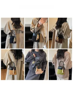 Detail showing various colors of stitched leather bucket bags with tassel charms on models