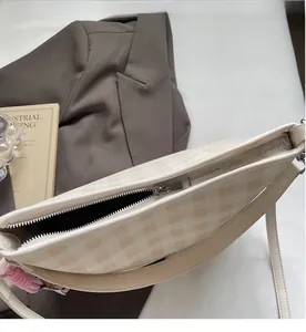 Détail de la fermeture éclair et du motif à damier beige sur le sac à main minimaliste
