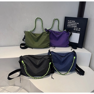 Detailed display of four plaid crossbody bags in green, purple, black, and navy with neon straps
