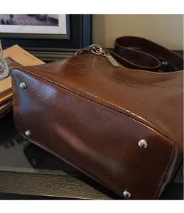 Close-up of vintage brown tote bag bottom with four silver metal protective rivets